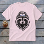 Pink t-shirt with black raccoon wearing beanie with mountain patch.