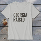 Light grey v-neck t-shirt with "GEORGIA RAISED" text.