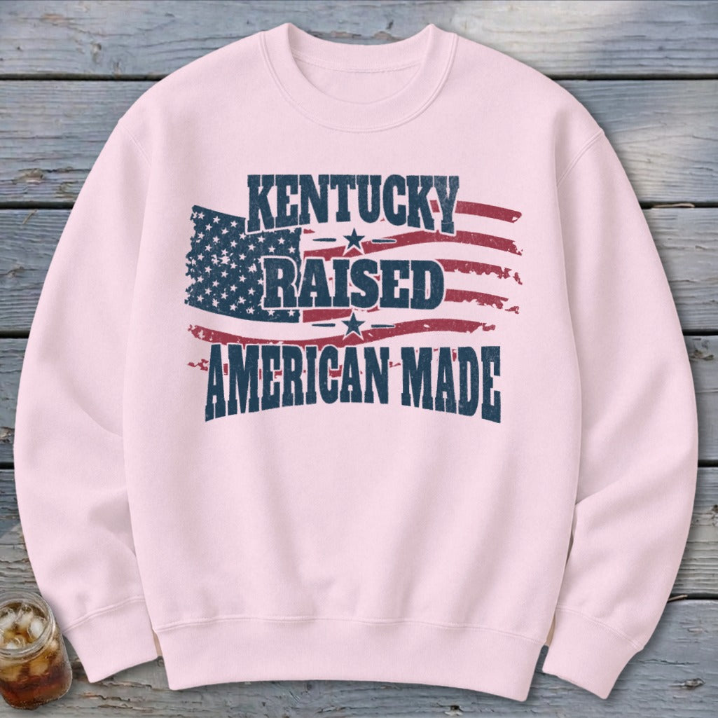 Pink sweatshirt with "Kentucky Raised American Made" and distressed American flag graphic.