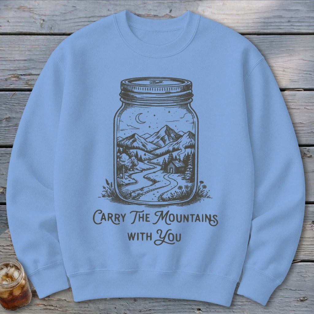 Light blue crewneck sweatshirt featuring a jar illustration containing a mountain landscape and text.