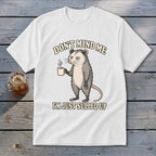 White t-shirt with opossum holding coffee mug and text "DON'T MIND ME I'M JUST SULLED UP".