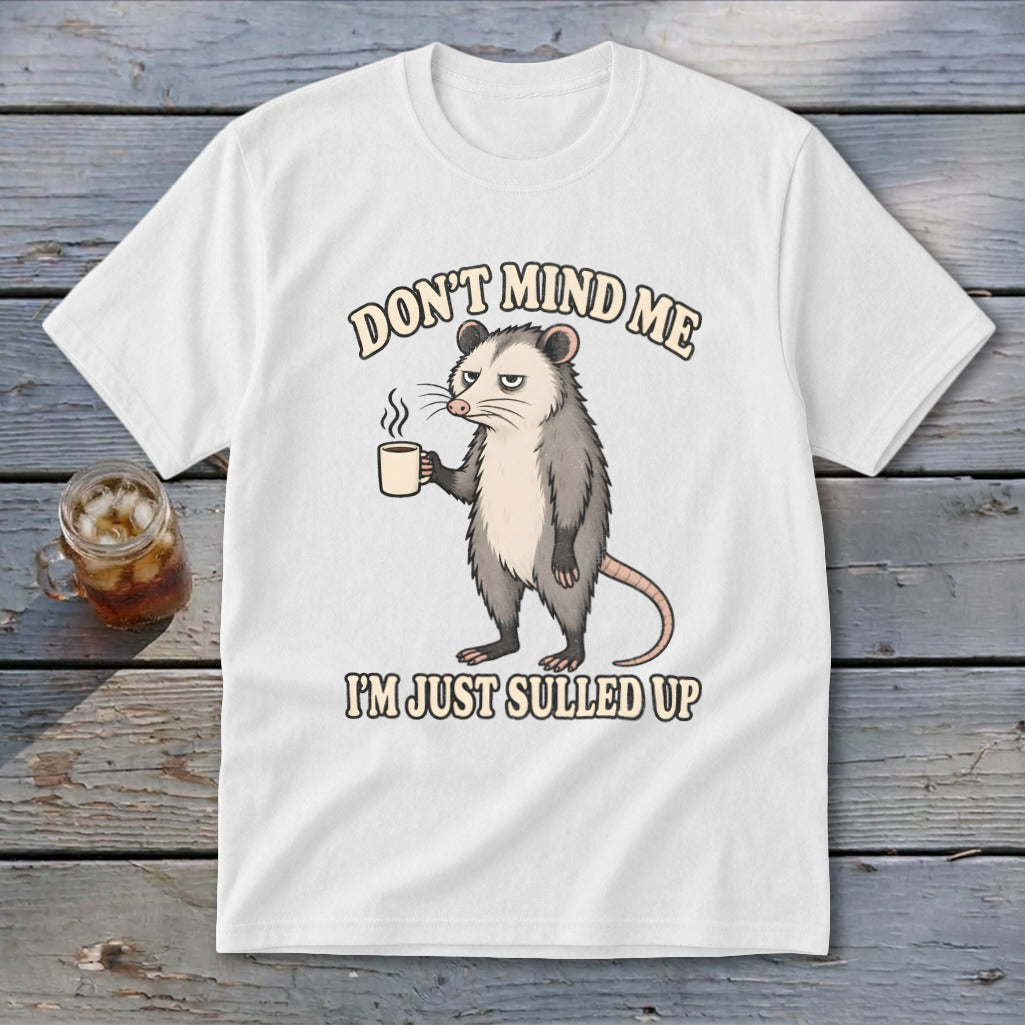 White t-shirt with opossum holding coffee mug and text "DON'T MIND ME I'M JUST SULLED UP".