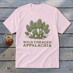Pink t-shirt with a green graphic of morel mushrooms and text "Wild Foraged Appalachia".