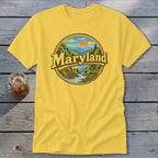 Yellow t-shirt with circular Maryland nature scene graphic featuring a deer and sunset.