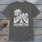 T-shirt with white graphic of a farmhouse, trees, fence, and text "OLD HOME PLACE".