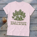 Pink t-shirt with a green graphic of morel mushrooms and the text "WILD FORAGED APPALACHIA".
