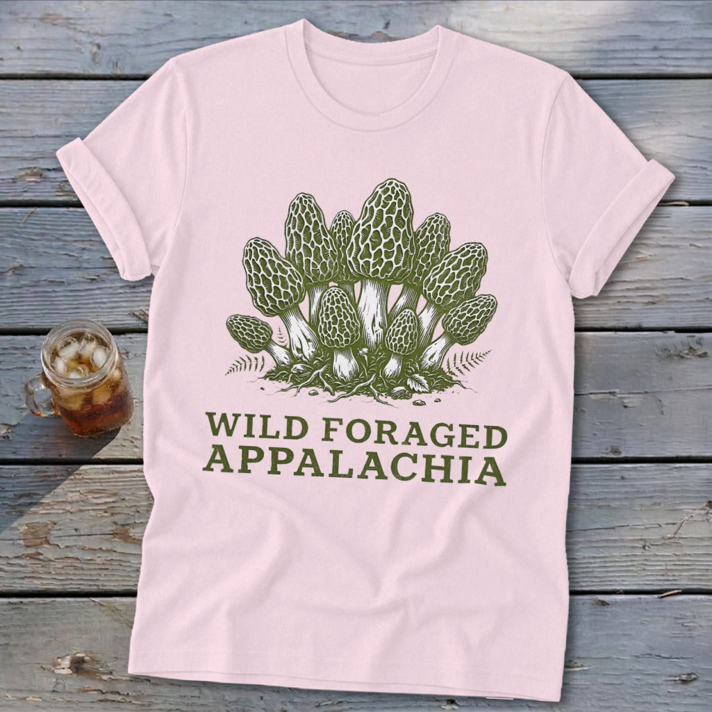 Pink t-shirt with a green graphic of morel mushrooms and the text "WILD FORAGED APPALACHIA".