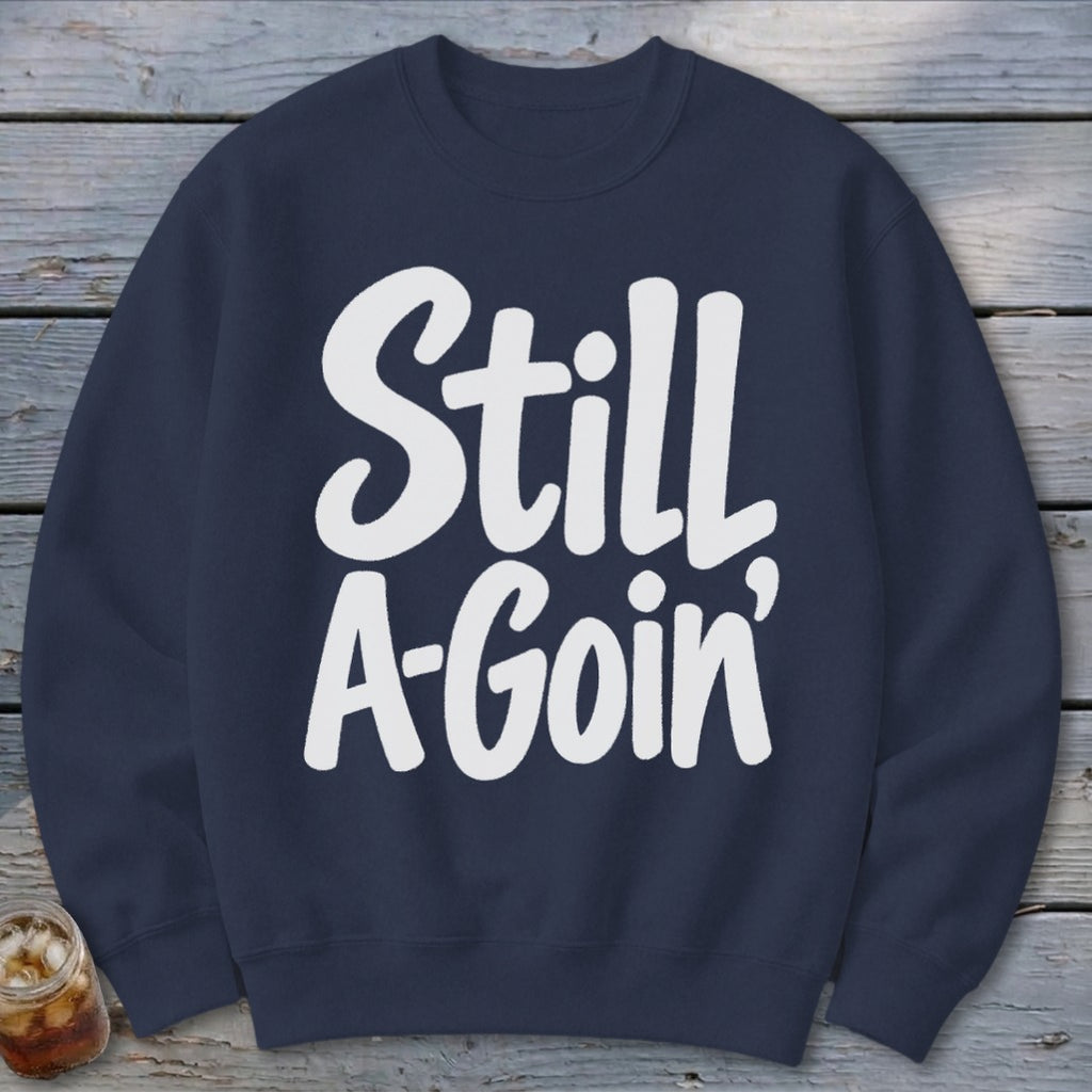 A dark blue crewneck sweatshirt with the white text Still A-Goin' centered on the chest.