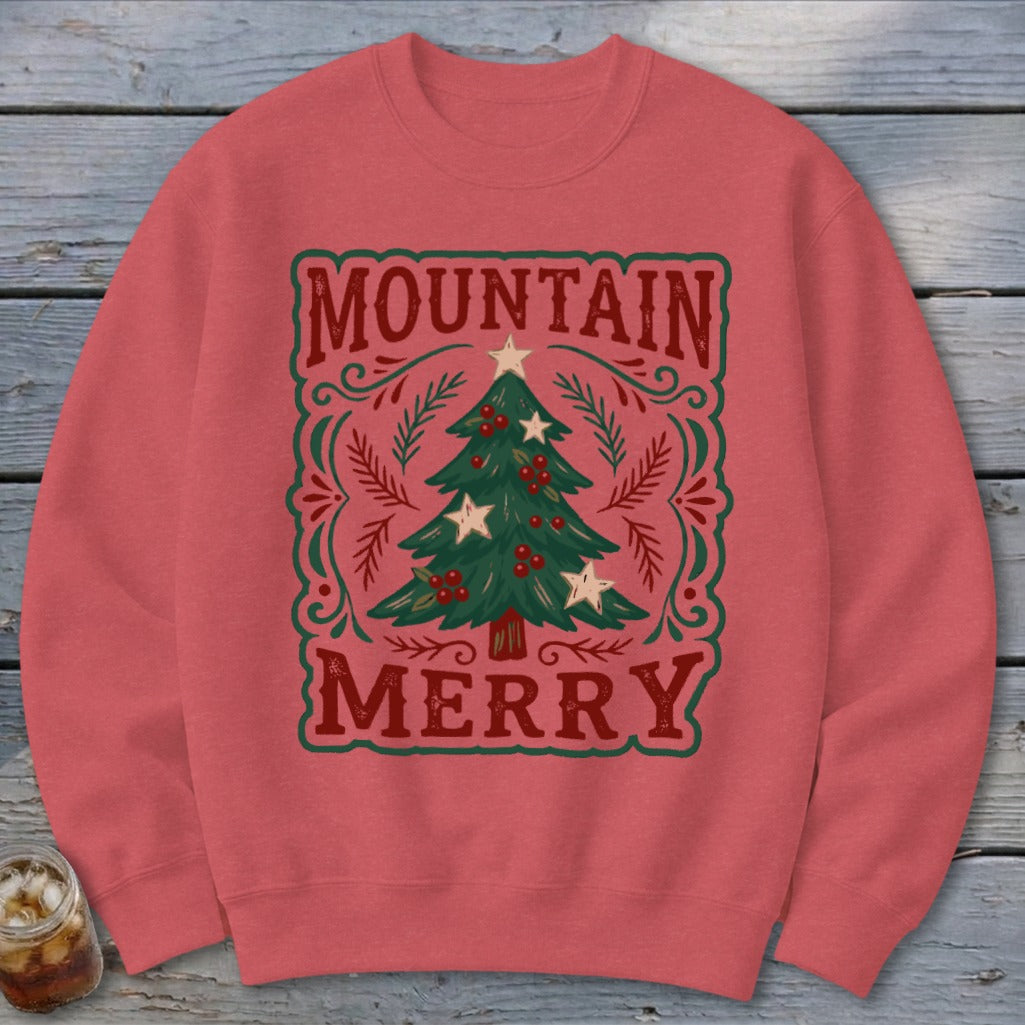 Red crewneck sweatshirt featuring a Christmas graphic with the text Mountain Merry surrounding a decorated tree.