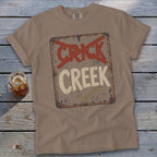 T-shirt featuring a distressed sign that says "CRICK" with red X's over it and "CREEK" with a checkmark.