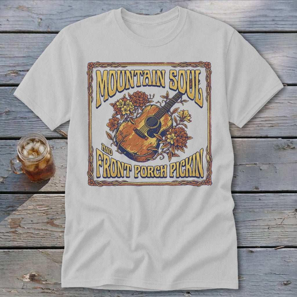 White t-shirt with "Mountain Soul and Front Porch Pickin" text and acoustic guitar graphic.
