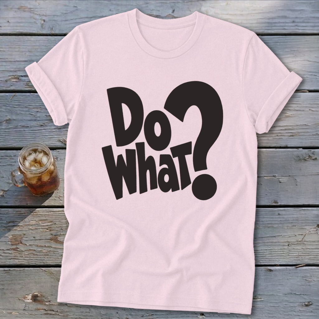 A light pink crewneck t-shirt with rolled sleeves features black text reading Do What? on a wooden background.
