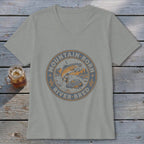 T-shirt with circular graphic of jumping trout, mountains, and text "MOUNTAIN BORN RIVER BRED".