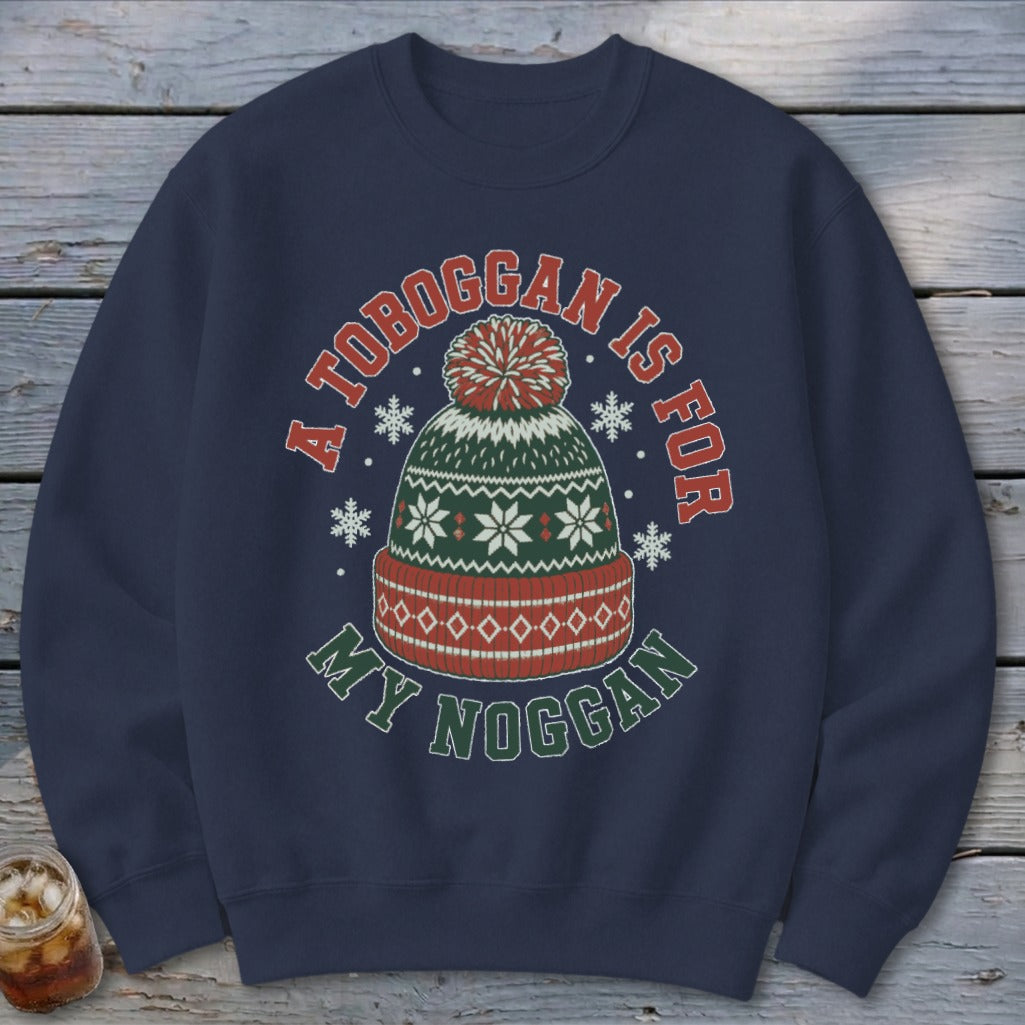 Dark blue crewneck sweatshirt featuring a graphic of a winter beanie and the text A TOBOGGAN IS FOR MY NOGGAN.