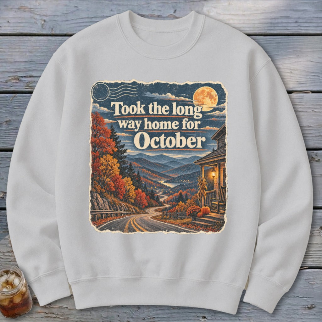 Sweatshirt with scenic autumn mountain road, house, and "Took the long way home for October" text.