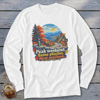 White long-sleeve shirt with a graphic of a scenic overlook with text "Peak weekend. Same playlist. New overlook."