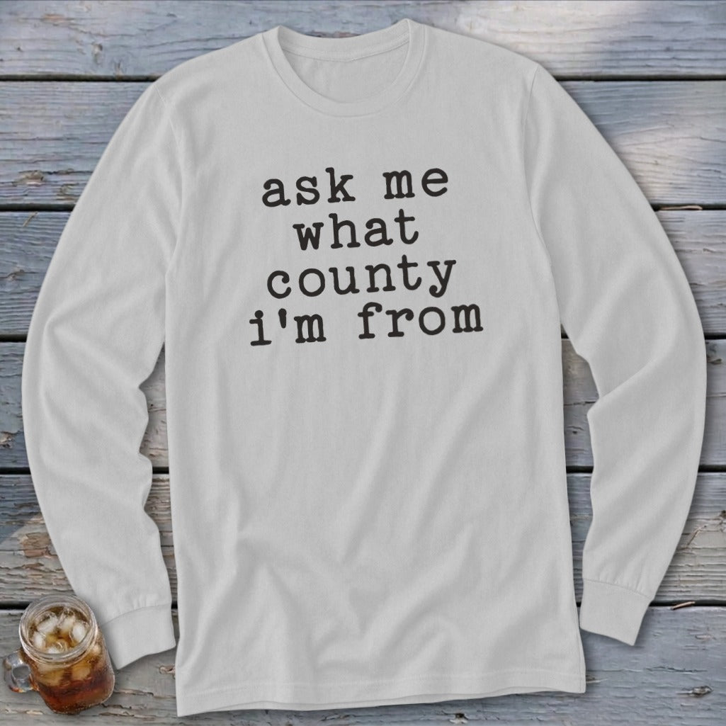 White long-sleeved shirt with "ask me what county i'm from" printed on the front.