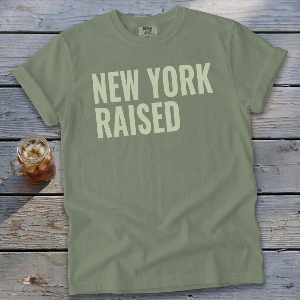 Olive green t-shirt with "NEW YORK RAISED" text in off-white.