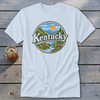 T-shirt featuring a circular design with "Kentucky" text, mountains, river, trees, and deer.