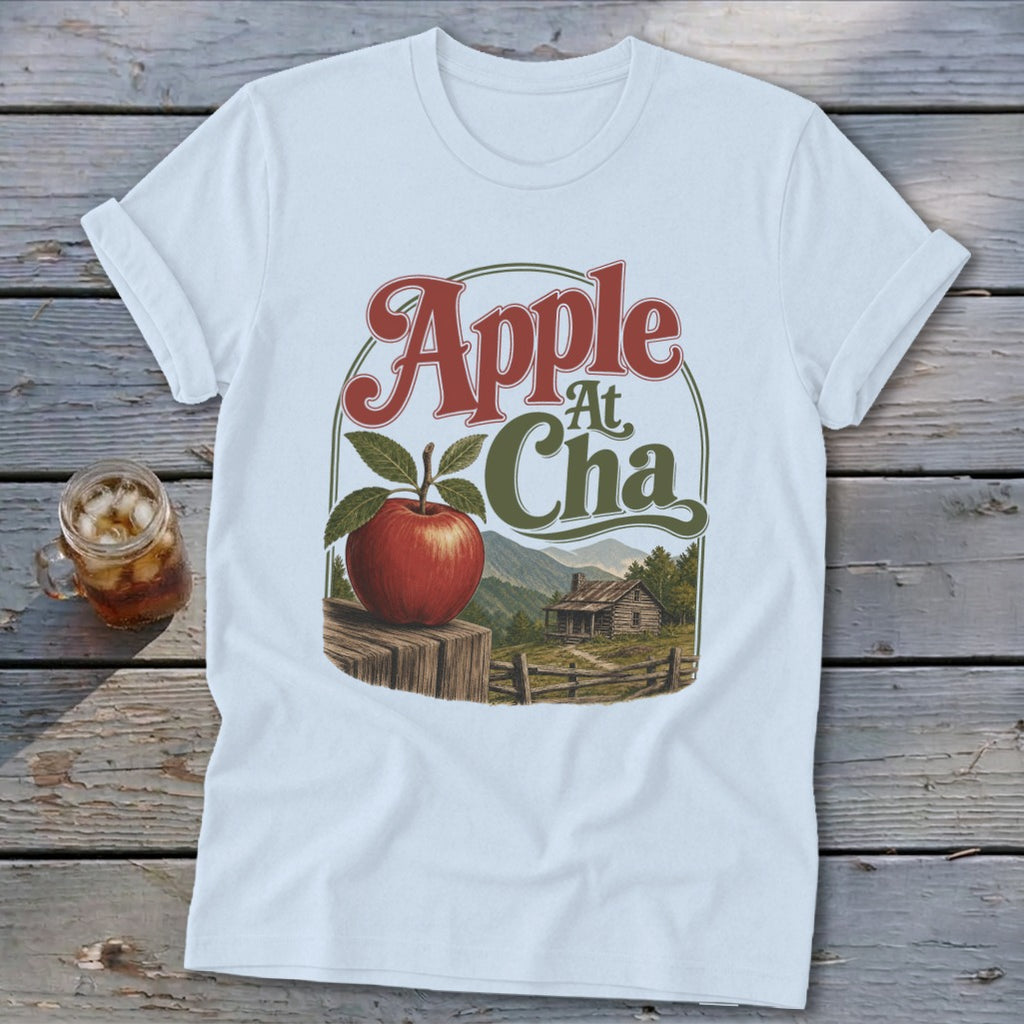 A white t-shirt featuring a retro graphic of an apple, mountains, and cabin with text.