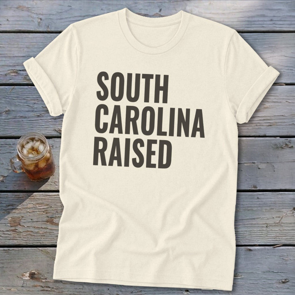 Cream t-shirt with "SOUTH CAROLINA RAISED" in dark gray text.