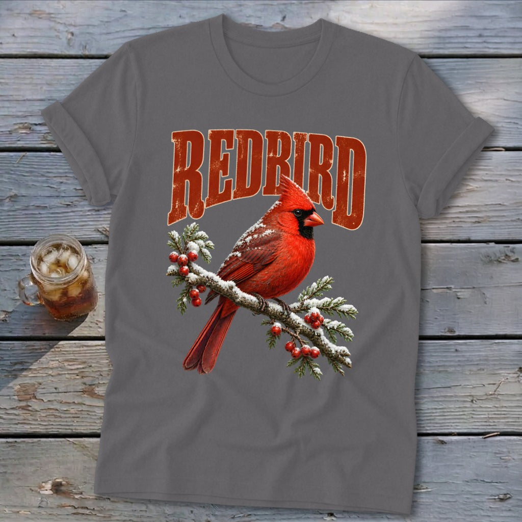 Charcoal gray t-shirt featuring a red cardinal perched on a snowy branch beneath the text "REDBIRD".
