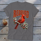 Charcoal gray t-shirt featuring a red cardinal perched on a snowy branch beneath the text "REDBIRD".