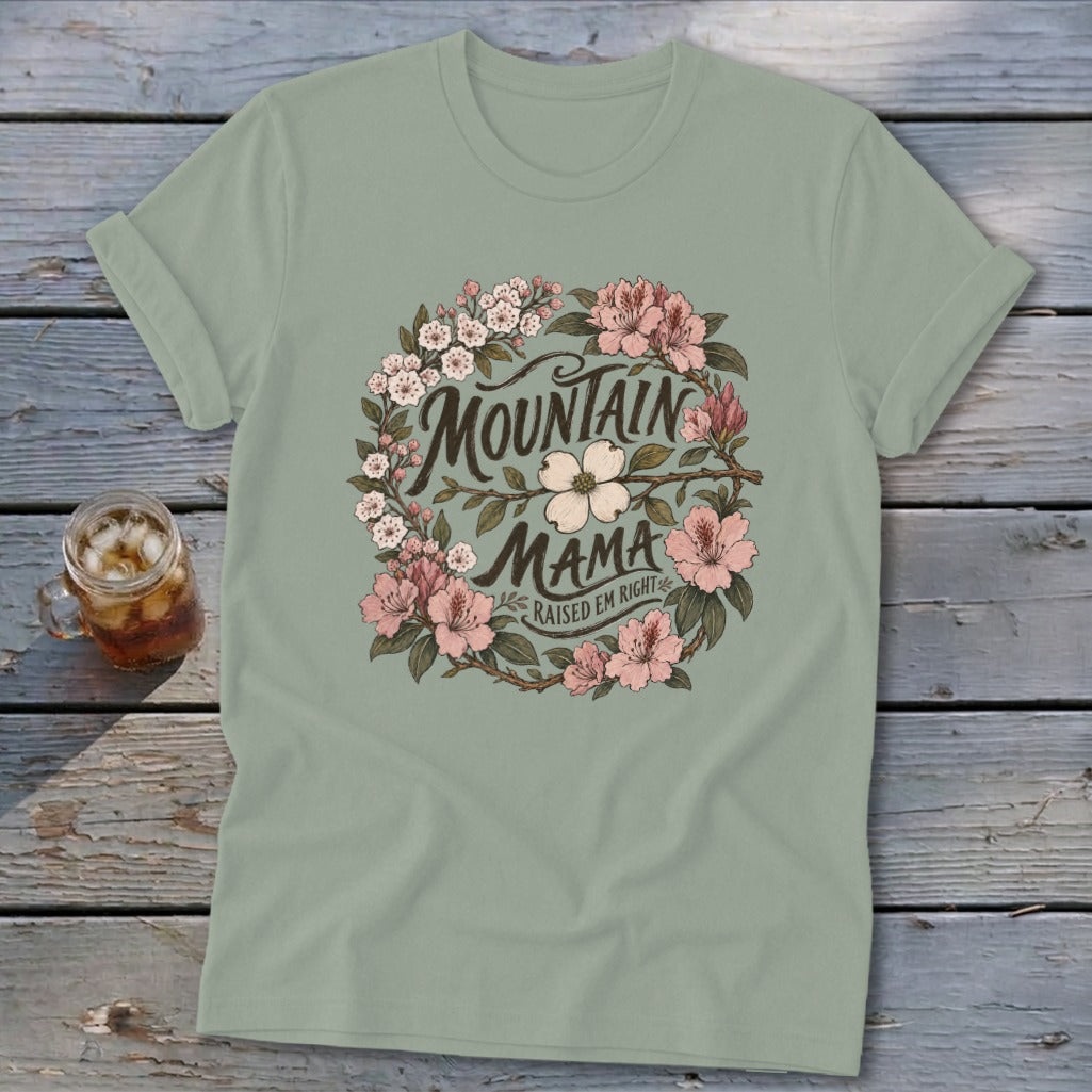 Green t-shirt with "Mountain Mama Raised Em Right" text surrounded by a floral wreath.
