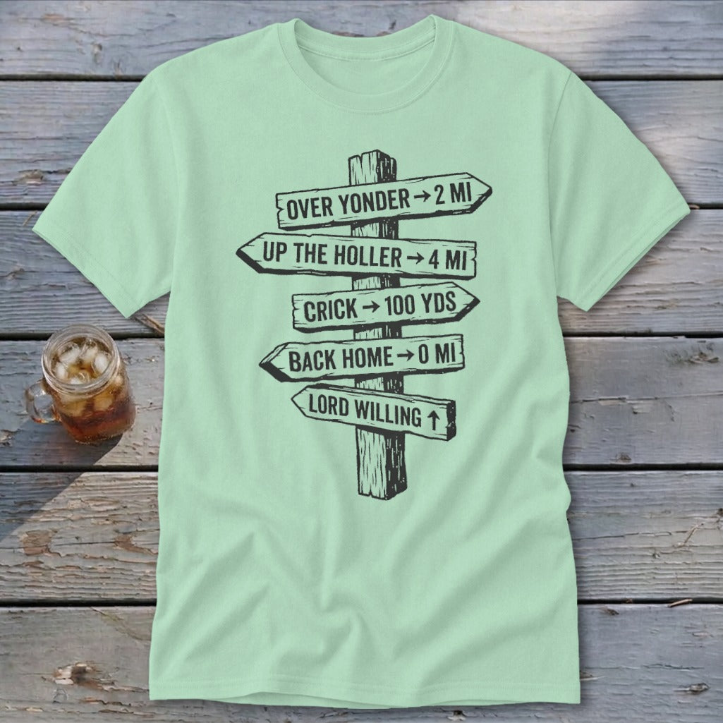 A light green t-shirt featuring a wooden signpost graphic with humorous directional distances.