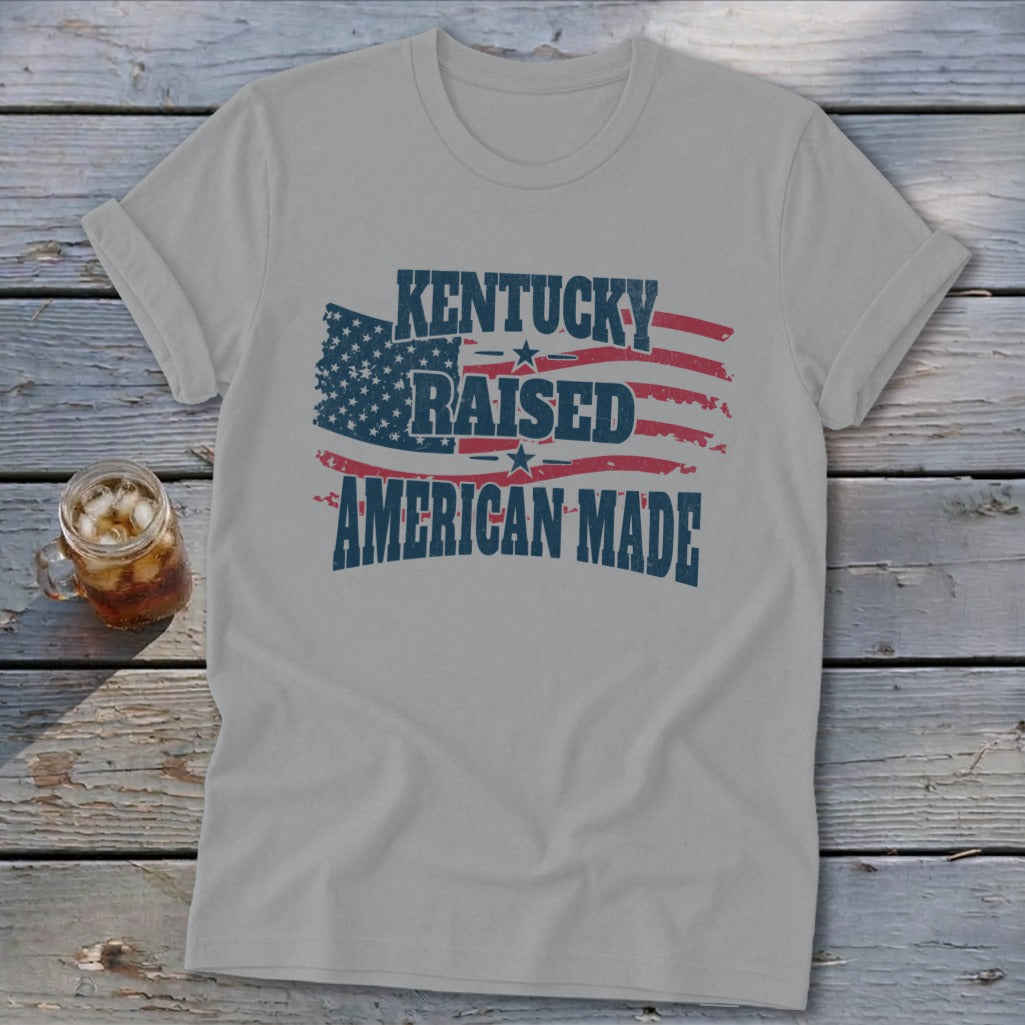 Grey t-shirt with "Kentucky Raised American Made" text over a distressed American flag design.