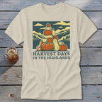 Cream-colored t-shirt featuring a retro graphic of stacked pumpkins, hills, and the text Harvest Days in the Highlands.