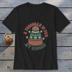Black V-neck t-shirt featuring a green, red, and white winter hat graphic and the text "A TOBOGGAN IS FOR MY NOGGAN."