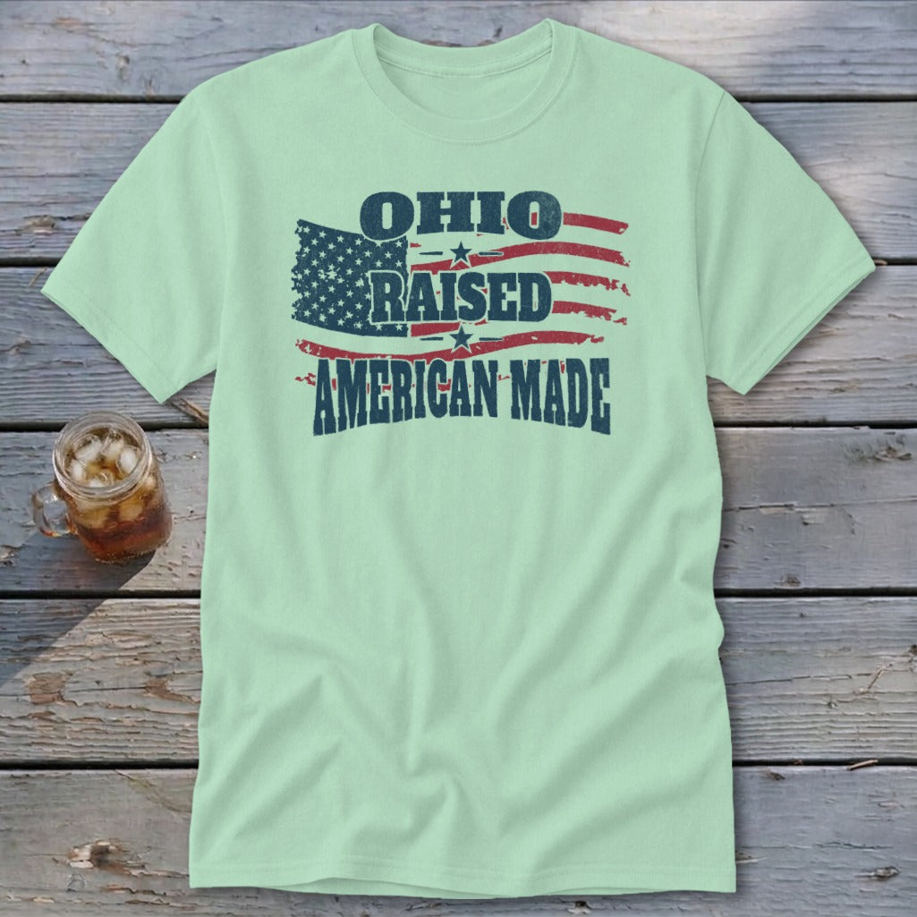 A light green crewneck t-shirt featuring a distressed American flag and text that reads Ohio Raised American Made.