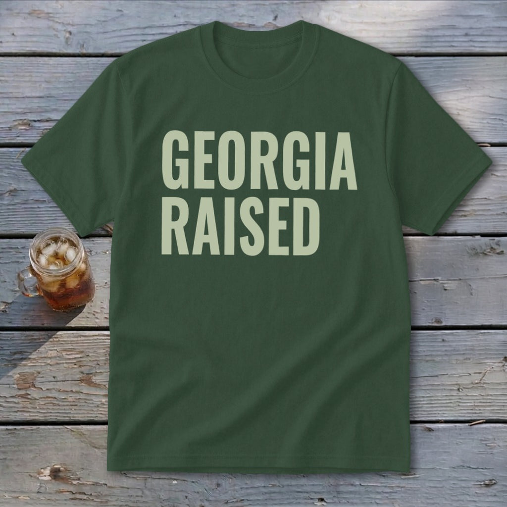 Green t-shirt with "GEORGIA RAISED" in cream text.