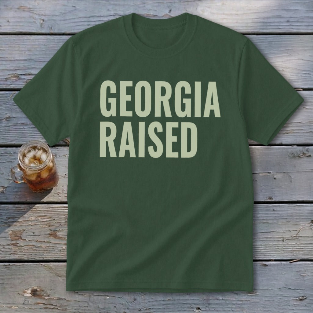 Green t-shirt with "GEORGIA RAISED" in cream text.