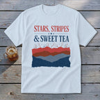A white t-shirt featuring the red, white, and blue text Stars, Stripes & Sweet Tea above layered patriotic mountain graphics.