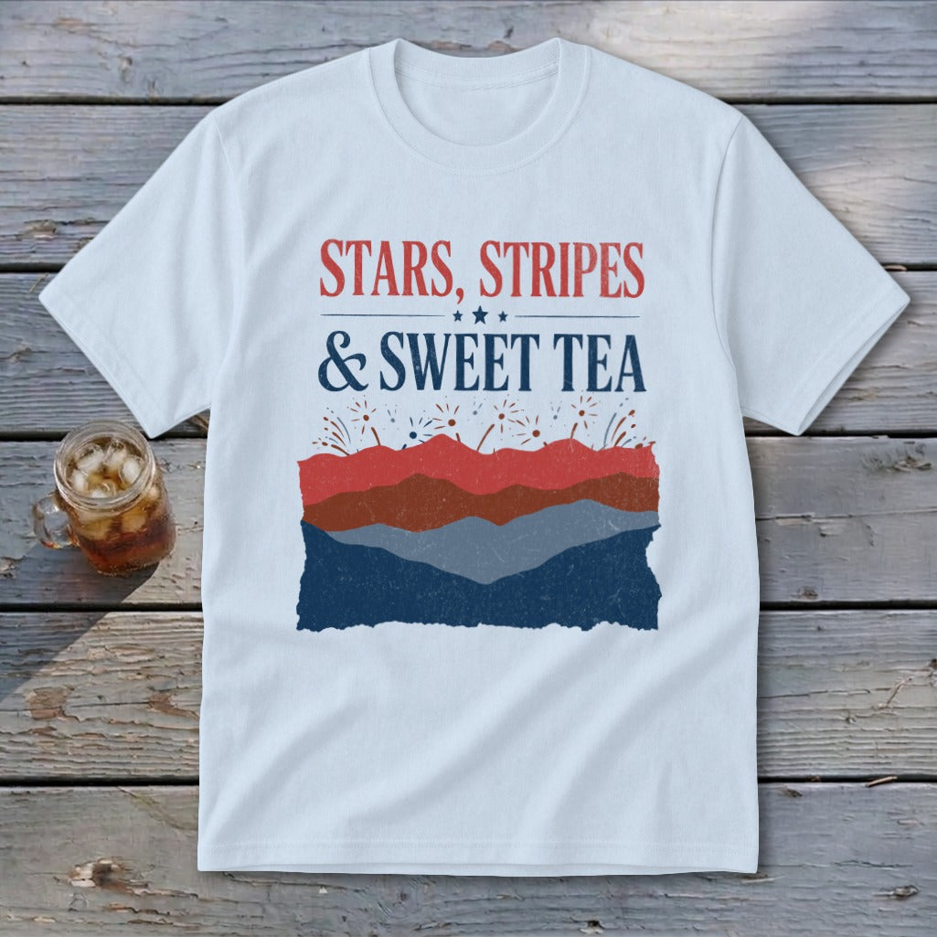 A white t-shirt featuring the red, white, and blue text Stars, Stripes & Sweet Tea above layered patriotic mountain graphics.