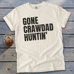 Cream t-shirt with black text reading "GONE CRAWDAD HUNTIN'".