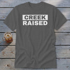Gray t-shirt with white text that reads "CREEK RAISED".