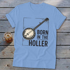 Light blue t-shirt with a banjo graphic and text "BORN IN THE HOLLER".