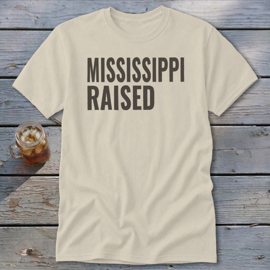 Cream t-shirt with "MISSISSIPPI RAISED" printed in dark gray text.
