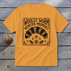 Gold crewneck t-shirt with a block-print graphic of a woolly worm and text reading Woolly Worm Winter Prophet.