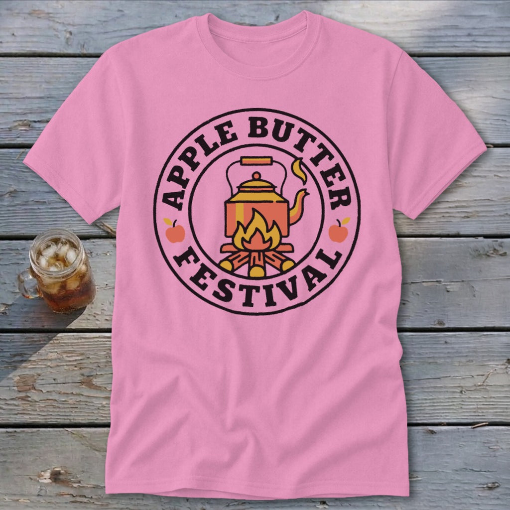 Pink t-shirt with circular graphic featuring a kettle over a campfire and text "Apple Butter Festival".
