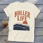 Off-white t-shirt with short rolled sleeves, featuring a retro mountain graphic and the text Holler Life.