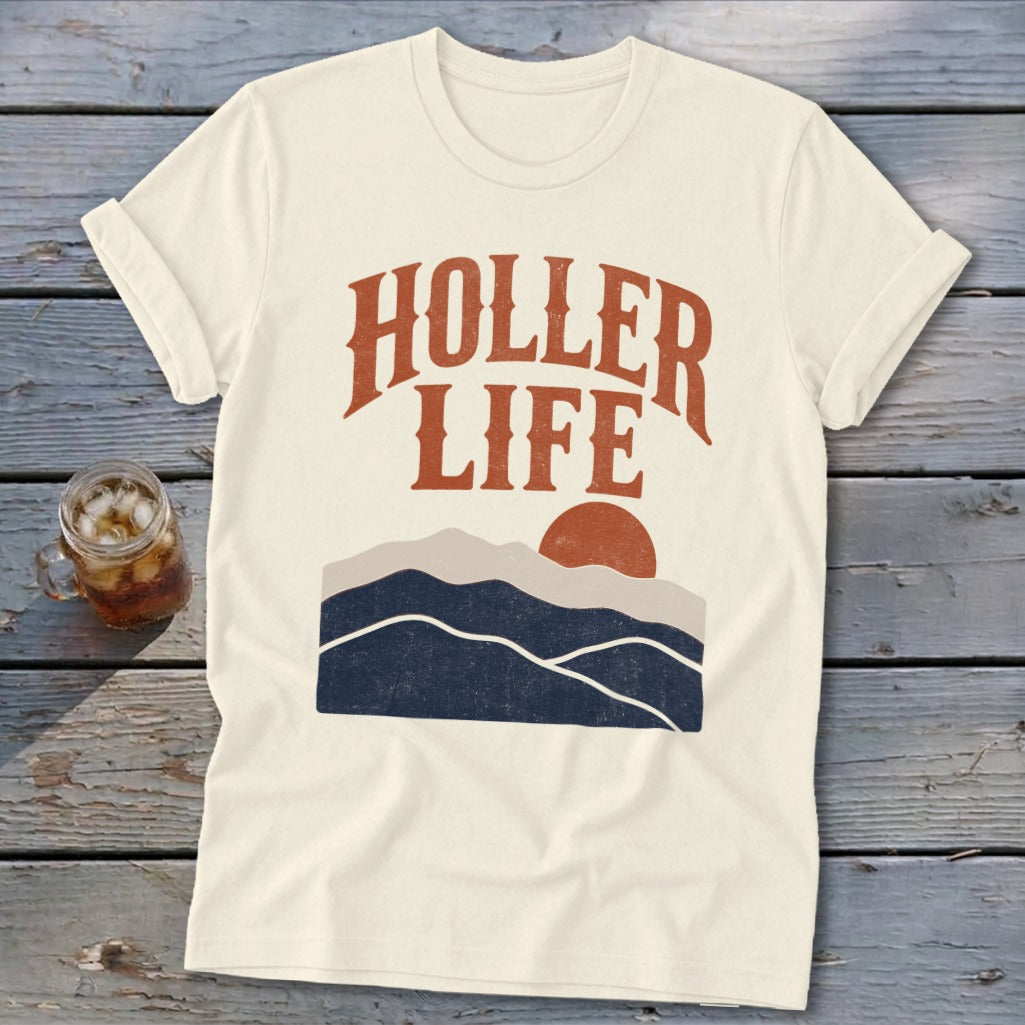 Off-white t-shirt with short rolled sleeves, featuring a retro mountain graphic and the text Holler Life.