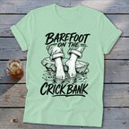 Light green t-shirt with "Barefoot on the Crick Bank" text and graphic.