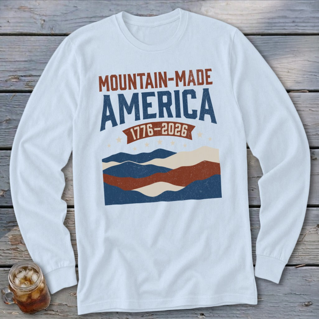 White long-sleeve t-shirt with a vintage graphic featuring the text Mountain-Made America and mountain landscape.