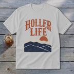 Light gray t-shirt with orange text reading HOLLER LIFE above a sunset landscape graphic.