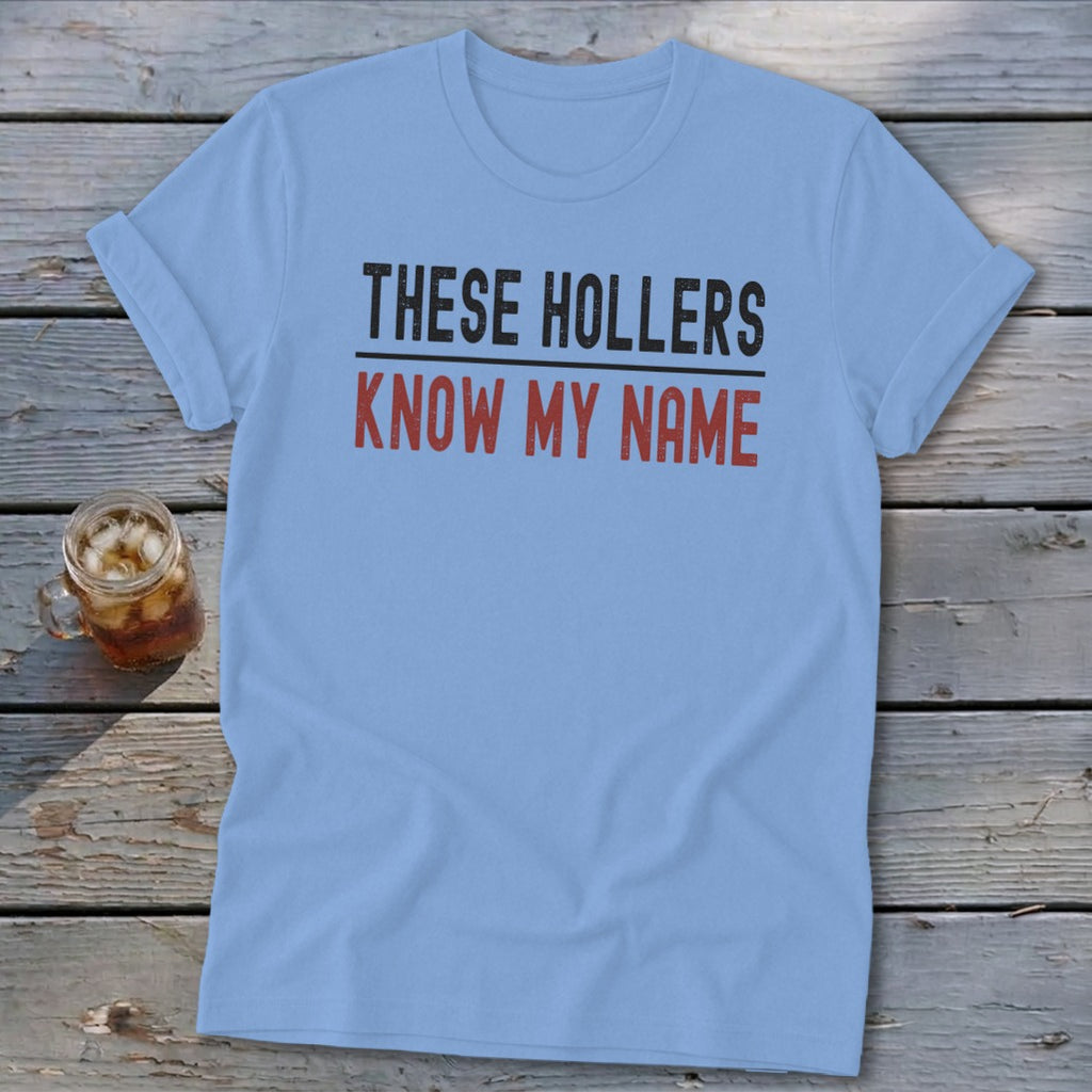 Light blue t-shirt with "THESE HOLLERS KNOW MY NAME" text.
