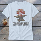 White t-shirt with an anvil, blooming tree, and text "FORGED IN FIRE ROOTED IN STONE."